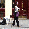 A Woman Pulls a Man with a Chain in the Streets