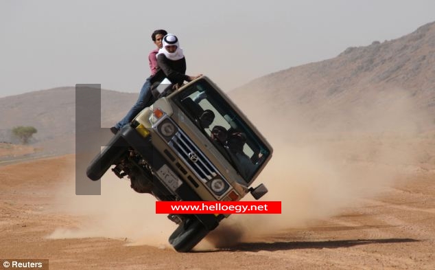 Daredevil Saudi Arabian craze of 'sidewalk skiing' brings new meaning to the term 'off-road' as drivers flip car onto just two wheels as passengers cling on outside